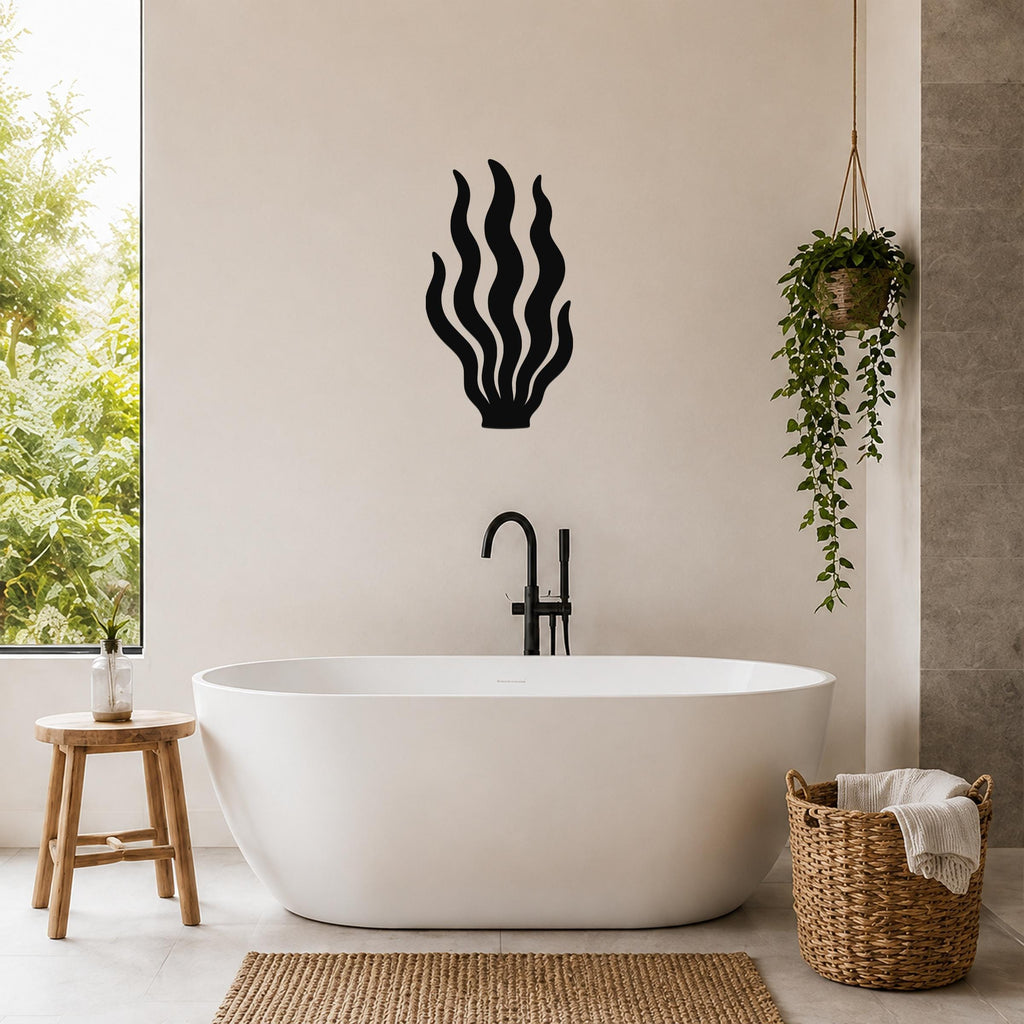 Black metal kelp wall art with flowing frond cutouts, mounted on a bathroom wall above a freestanding tub.
