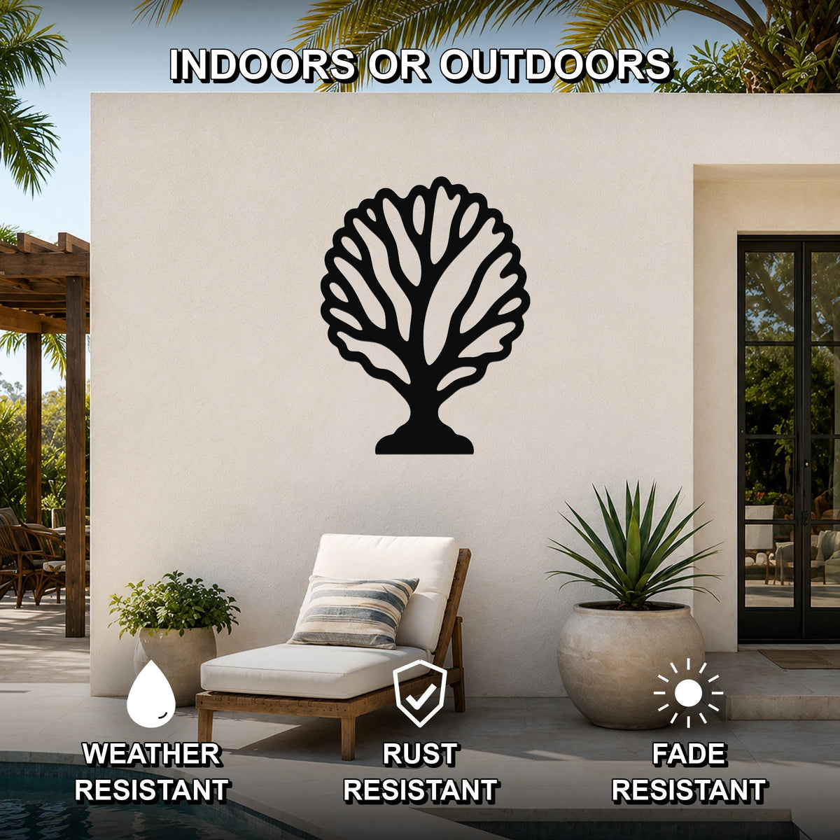 Black metal fan coral wall art with intricate branch cutouts, mounted on an outdoor patio wall above a lounge chair near a pool.