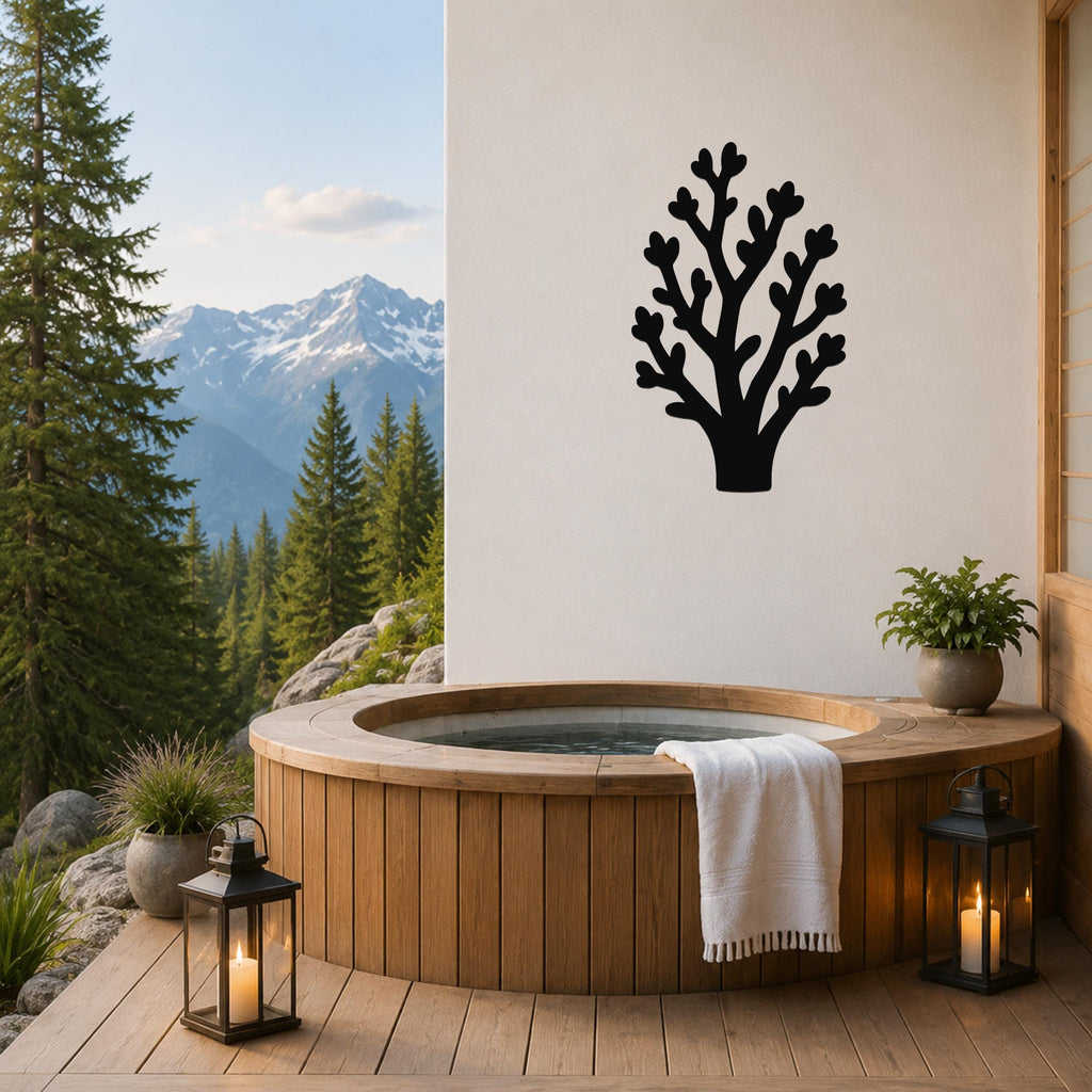 Black metal tree wall art with branch cutouts, mounted on a white wall above a wooden hot tub on a mountain-view patio.