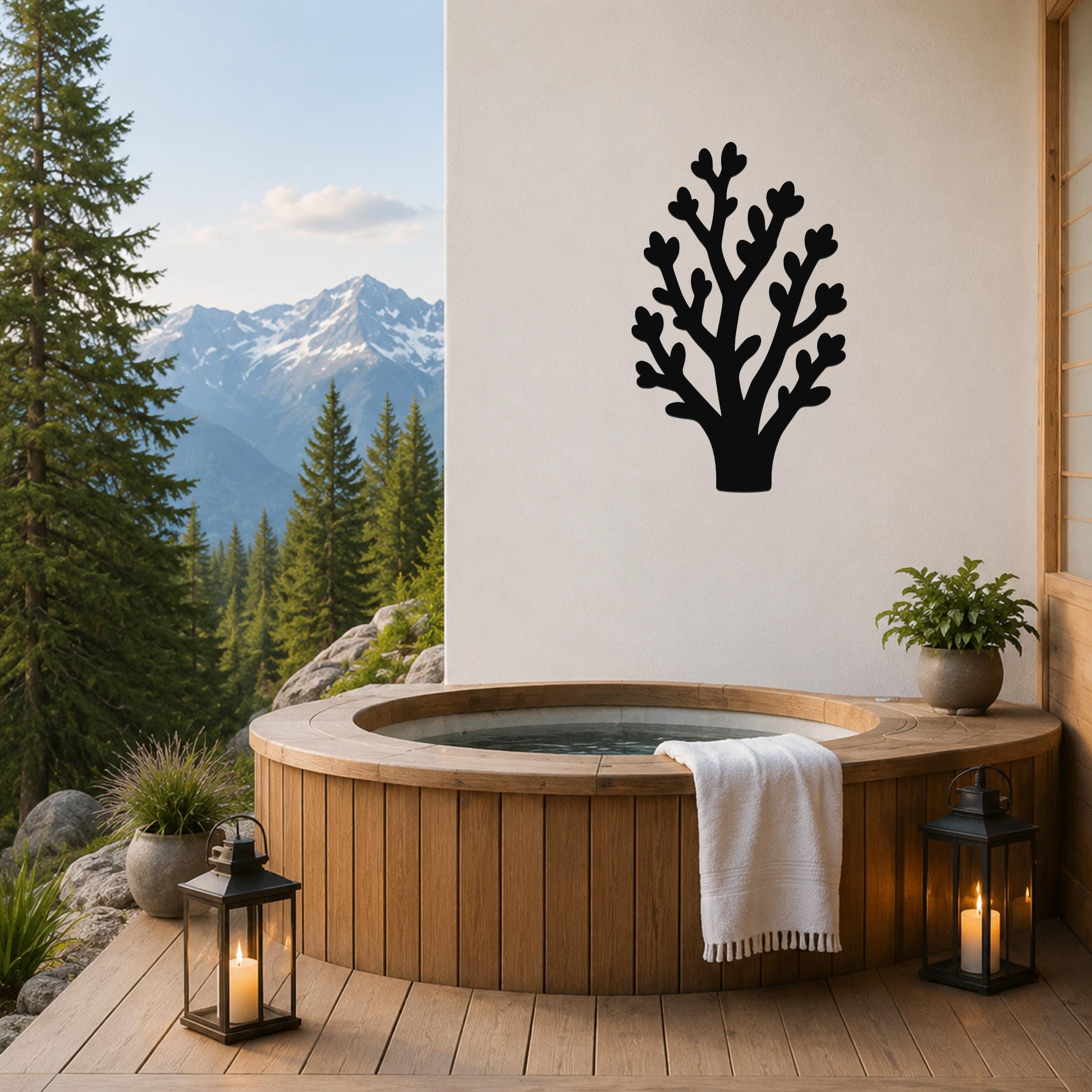 Black metal tree wall art with branch cutouts, mounted on a white wall above a wooden hot tub on a mountain-view patio.