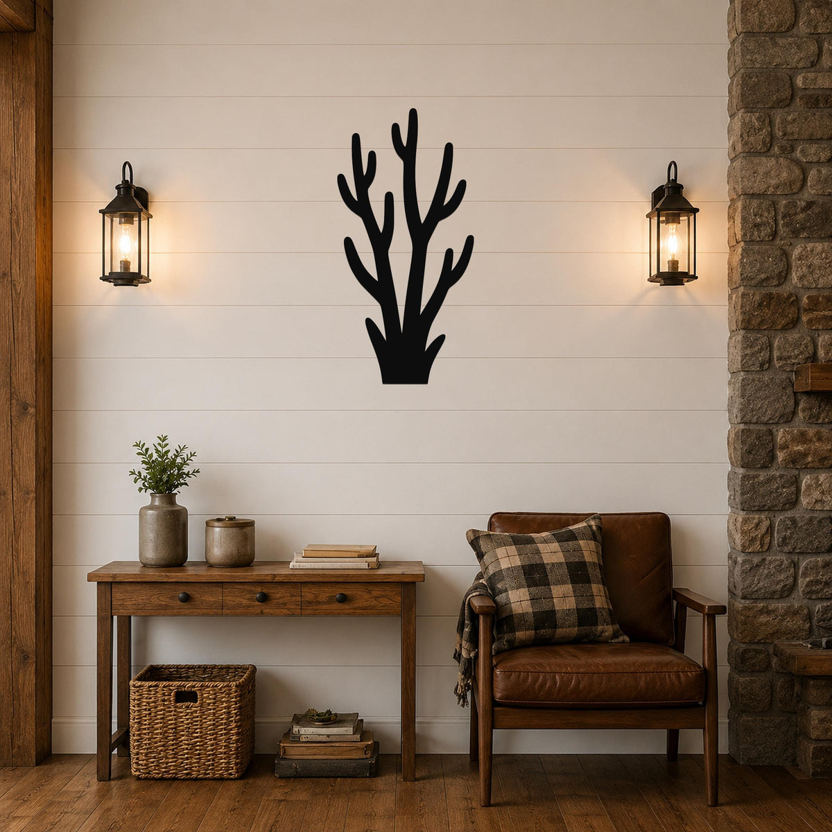 Black metal wall art in a desert branch silhouette, mounted on a shiplap wall above a wooden console table in a living room.