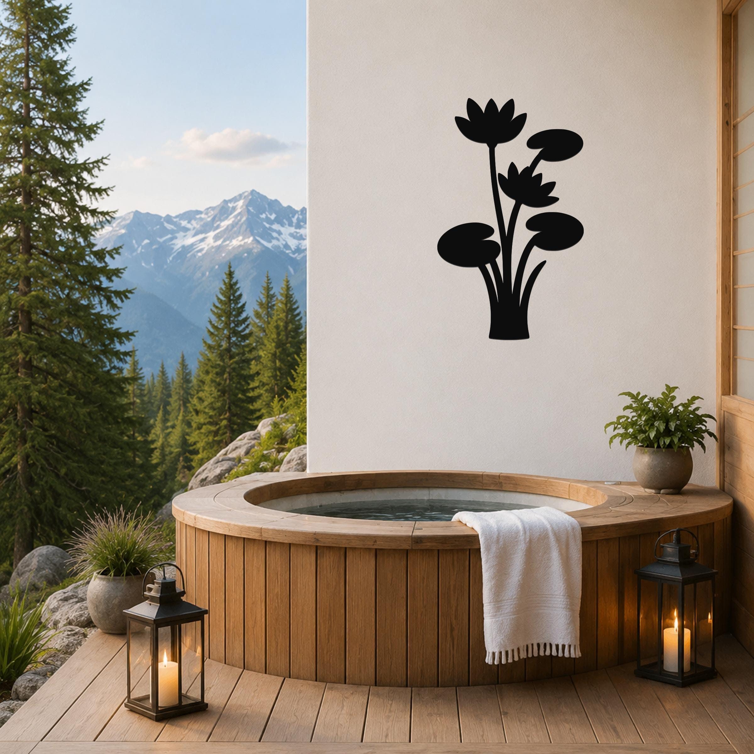 Black metal lotus water lily wall art with flower and leaf cutouts, mounted on a white wall above a wooden hot tub on a mountain-view patio.