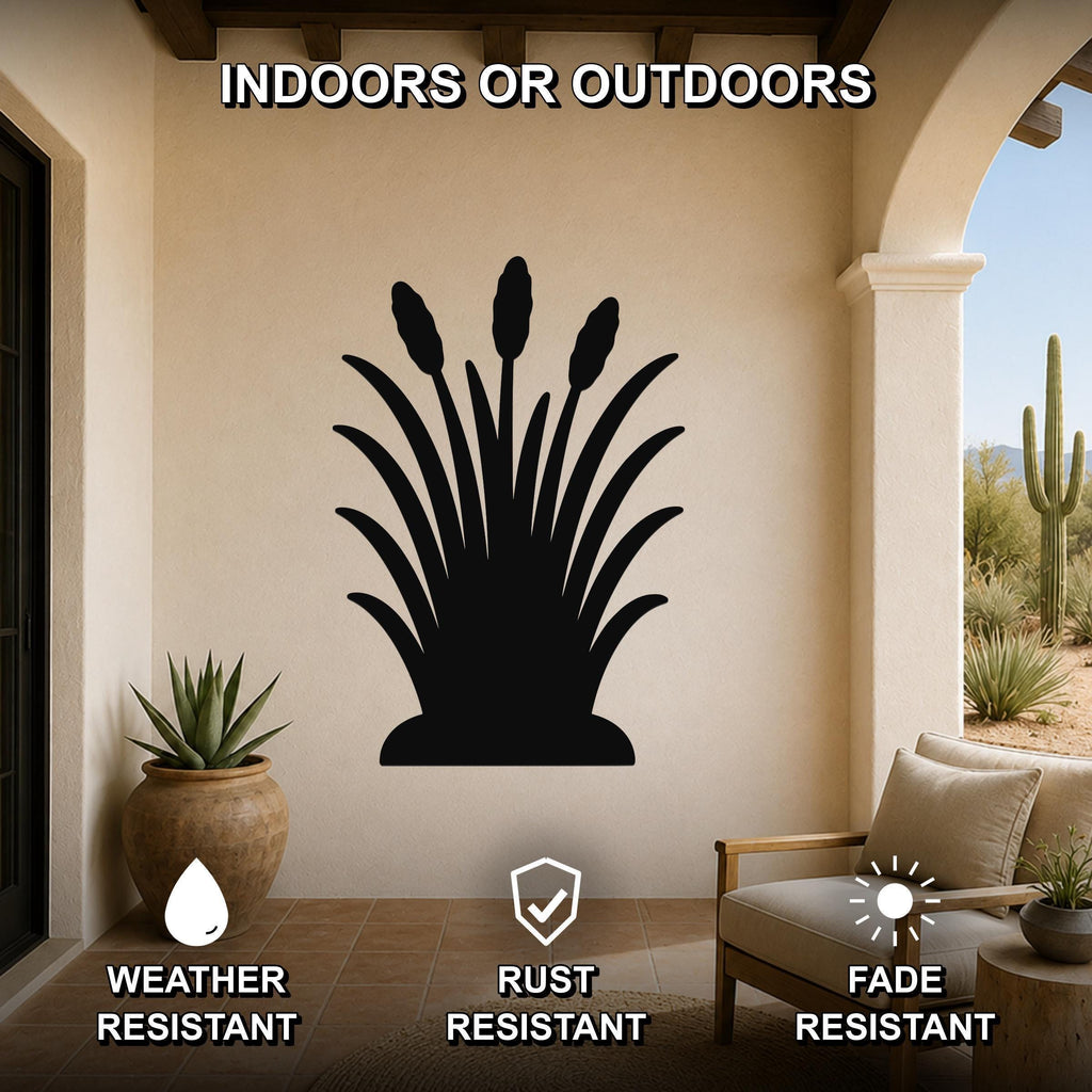 Black metal wall art silhouette of wild grass with tall seed heads, mounted on a beige outdoor patio wall above a potted succulent and a wooden chair.