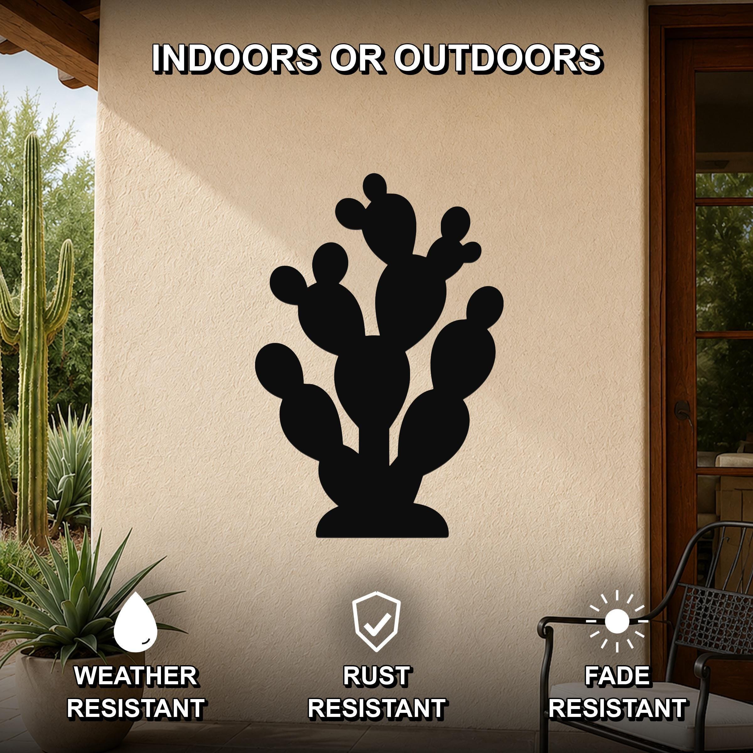 Black metal prickly pear cactus wall art with multiple segmented pads and internal cutouts, mounted on an outdoor patio wall above a potted plant.
