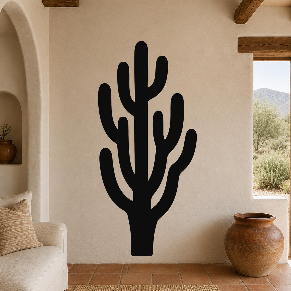 Black metal saguaro cactus wall art with branching cutouts, mounted on a stucco wall in a southwestern-style living room.