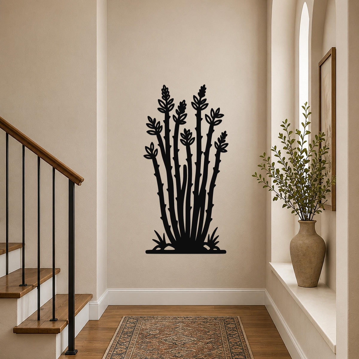 Black metal ocotillo wall art with detailed branch and leaf cutouts, mounted on a hallway wall above a patterned rug.