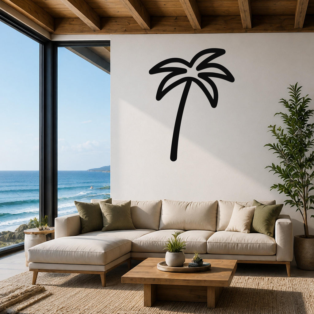 Black metal palm tree wall art silhouette mounted on a white wall above a beige sectional sofa in a living room with ocean views.