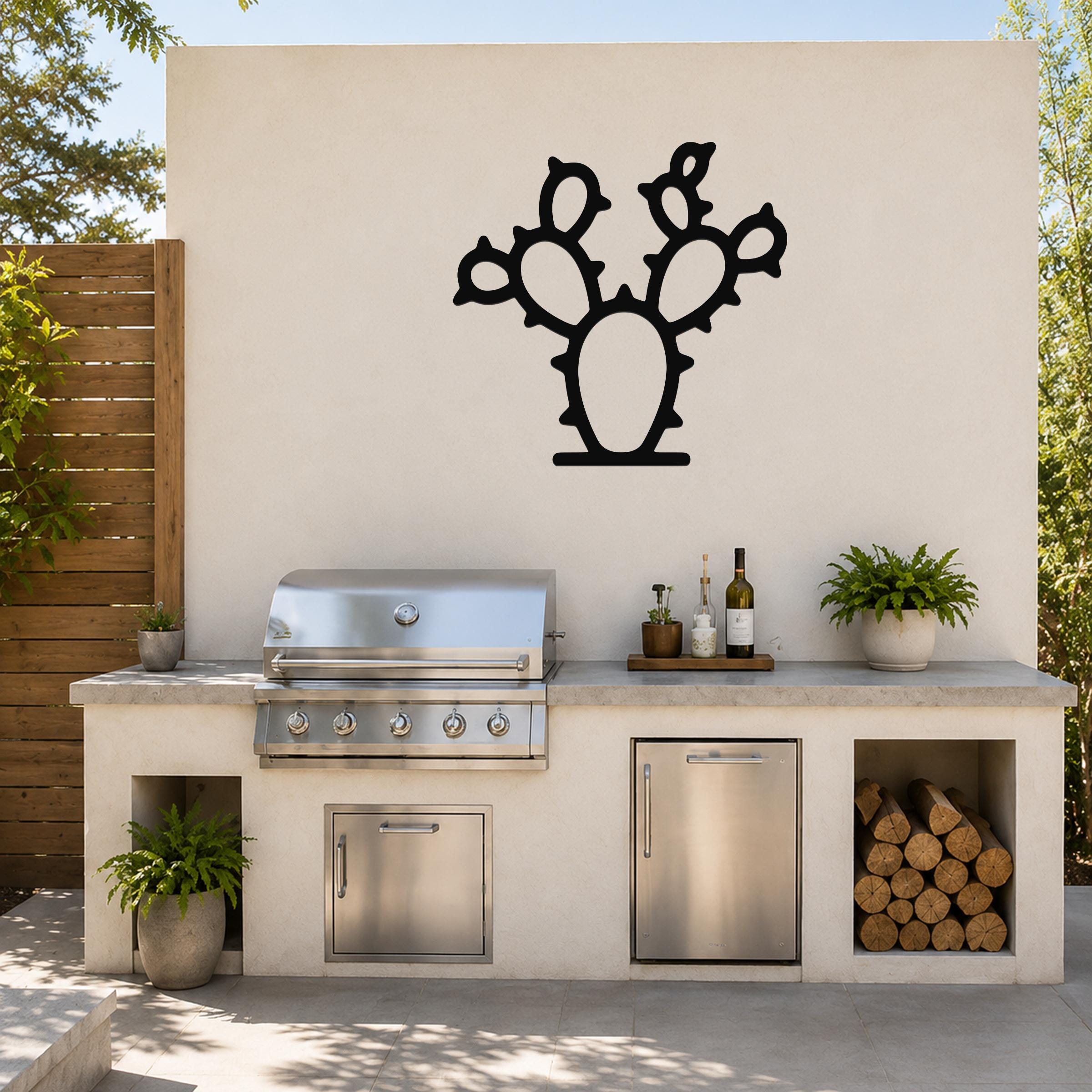 Black metal cactus wall art with a silhouette cutout of a prickly pear, mounted on a light-colored outdoor wall above a kitchen counter.