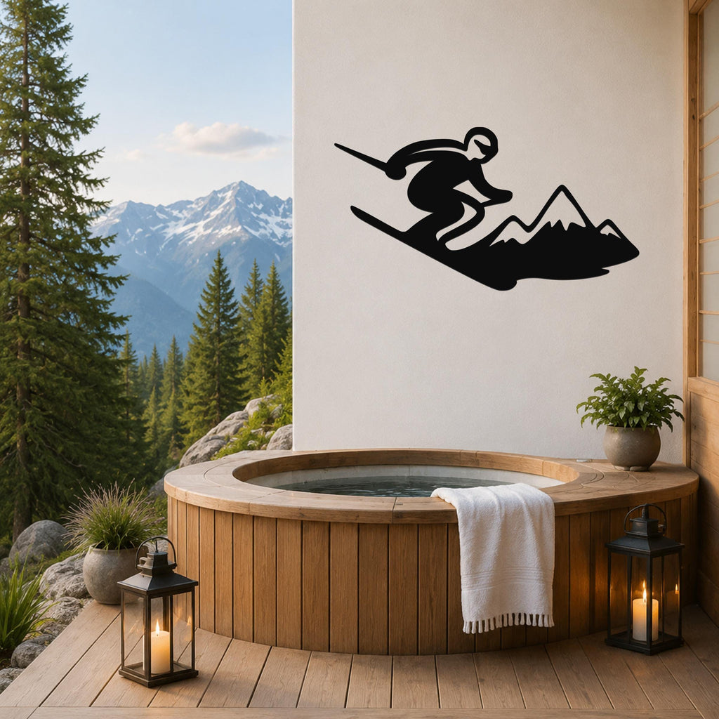 Black metal wall art silhouette of a skier in motion above a mountain, mounted on a white wall above a wooden hot tub on a deck with a mountain view.