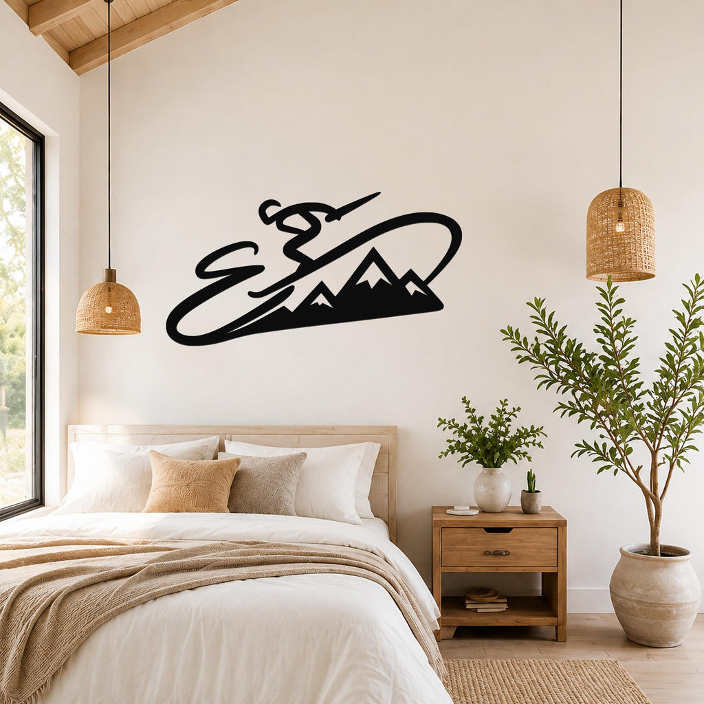 Black metal wall art silhouette of a skier in motion above a mountain range, mounted on a bedroom wall above a bed.