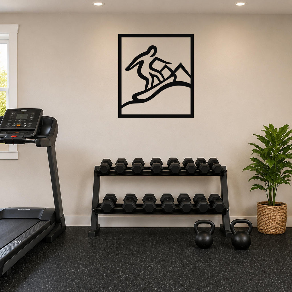 Black metal wall art with a snowboarder silhouette in motion, mounted on a wall above a dumbbell rack in a home gym.