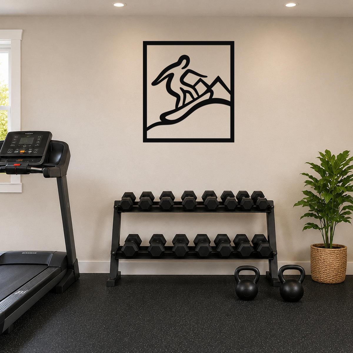 Black metal wall art with a snowboarder silhouette in motion, mounted on a wall above a dumbbell rack in a home gym.