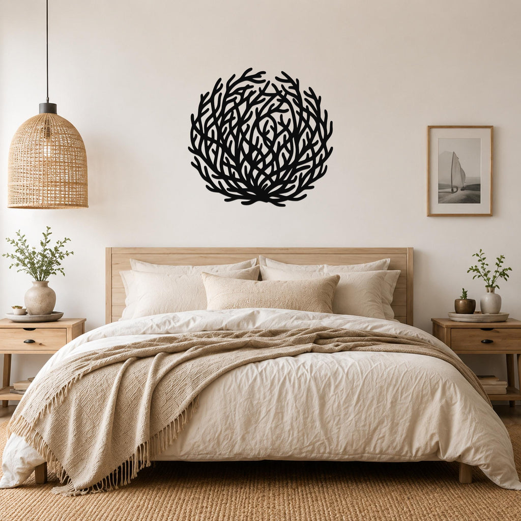 Black metal coral wall art with intricate branch cutouts, mounted above a bed in a neutral bedroom.
