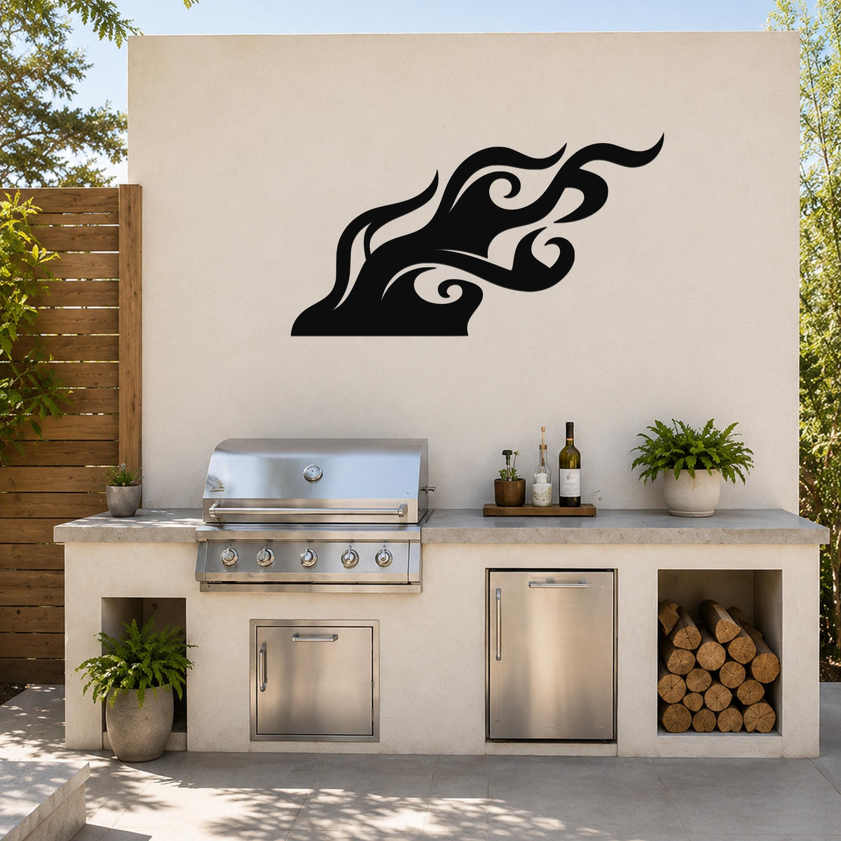 Black metal flame wall art with fluid swirl cutouts, mounted on an outdoor kitchen wall above a stainless steel grill.