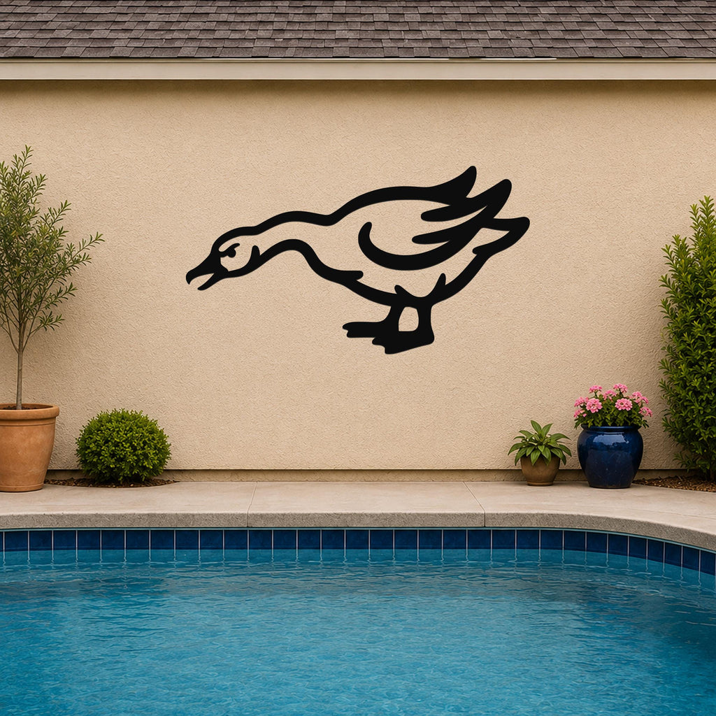 Black metal goose wall art with motion-line cutouts, mounted on a beige outdoor wall above a pool.