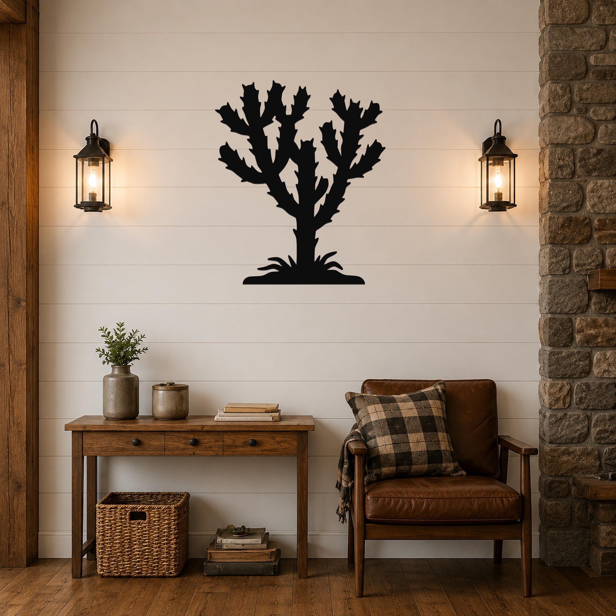 Black metal Cholla cactus wall art silhouette with branching arms and base, mounted on a white shiplap wall above a wooden console table in a living room.