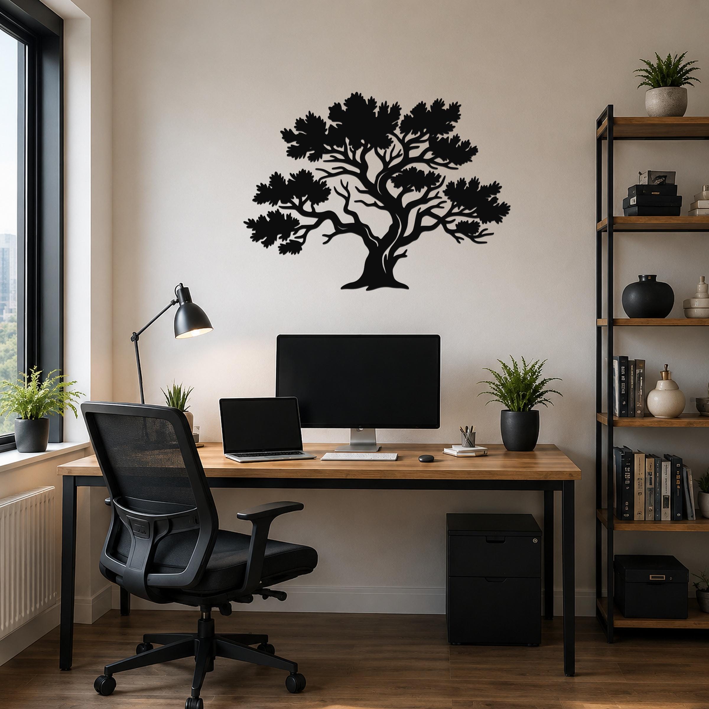 Black metal juniper tree wall art with detailed branch and leaf cutouts, mounted on a wall above a wooden desk in a home office.