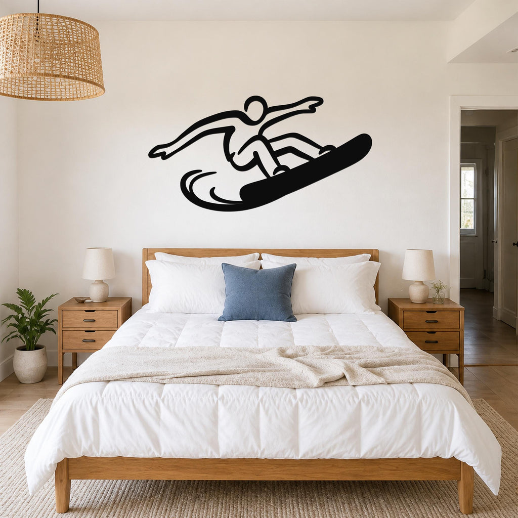Black metal snowboarder wall art silhouette with dynamic motion lines, mounted above a bed in a bedroom.