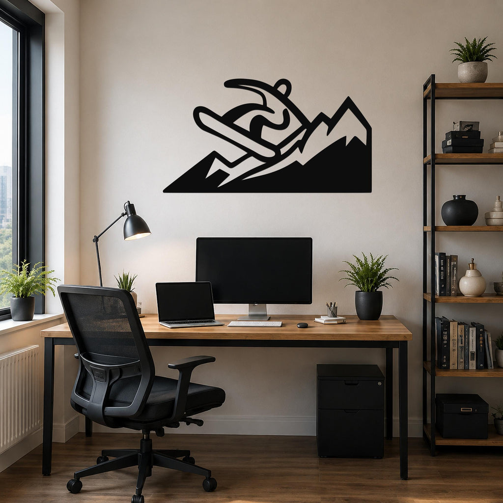 Black metal wall art featuring a snowboarder silhouette in motion above mountain peaks, mounted on a wall above a wooden desk in a home office.