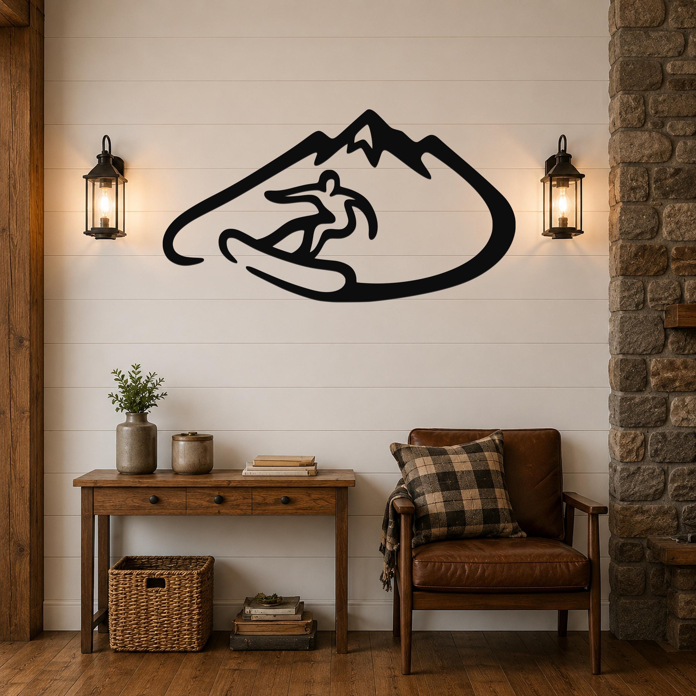 Black metal wall art featuring a minimalist silhouette of a snowboarder in a mountain, mounted on a shiplap wall above a wooden console table in a living room.