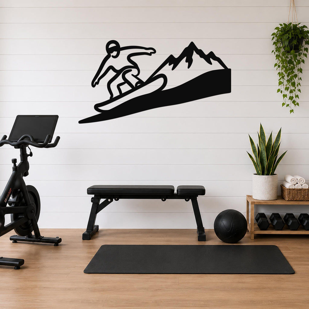 Black metal wall art featuring a snowboarder silhouette and mountain peaks, mounted on a white shiplap wall above a workout bench in a home gym.