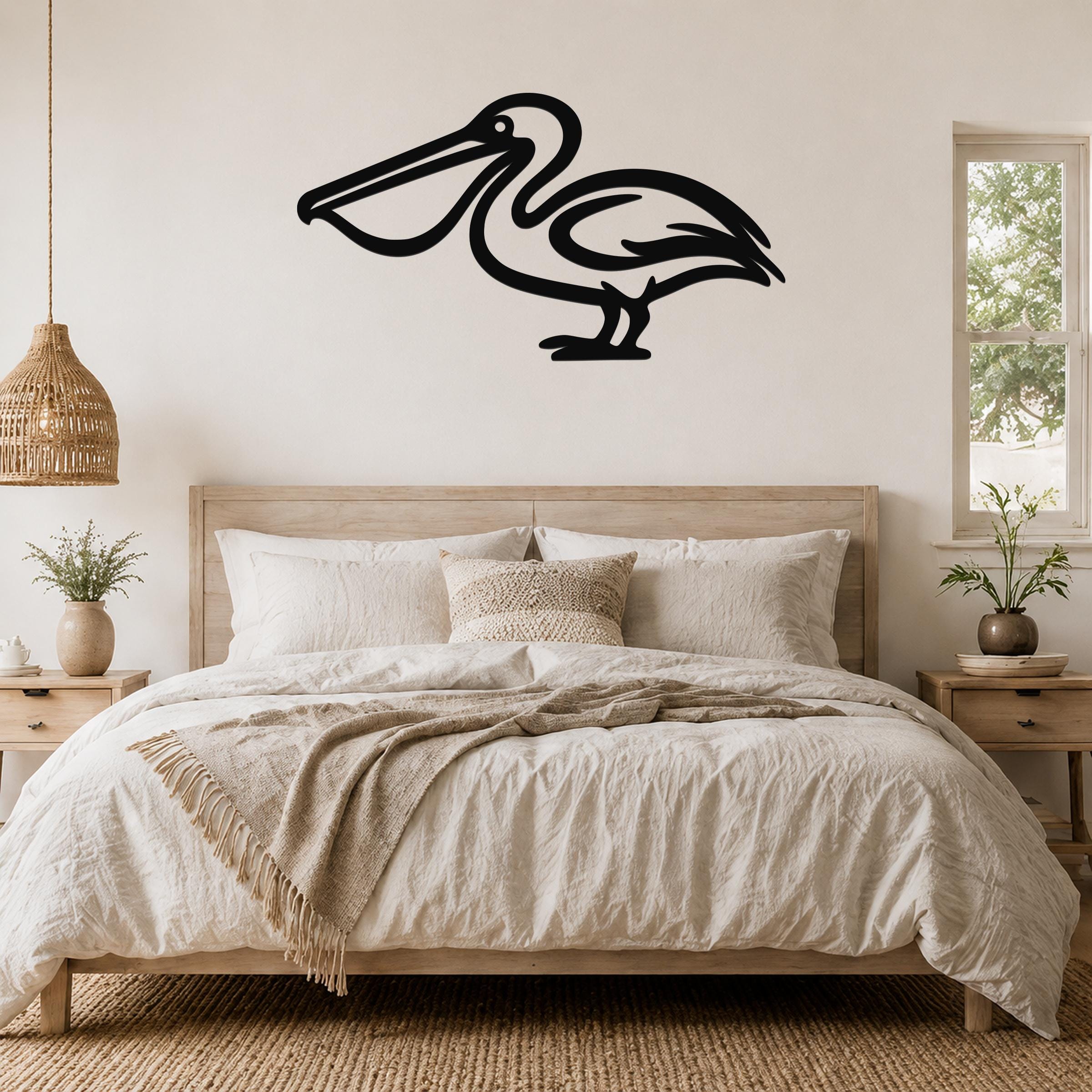 Black metal pelican wall art silhouette mounted above a wooden bed in a neutral bedroom.