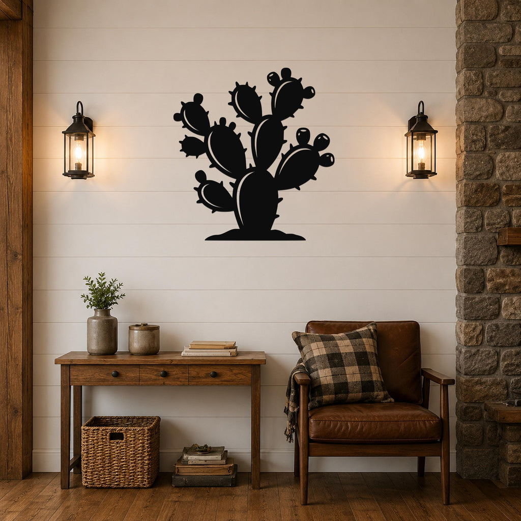 Black metal wall art cutout of a prickly pear cactus with multiple pads and spines, mounted on a white shiplap wall above a wooden console table in a living room.