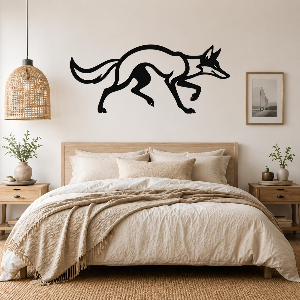Black metal coyote wall art in a running silhouette, mounted above a bed in a neutral bedroom.
