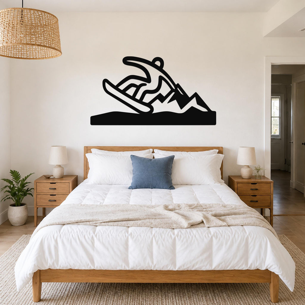 Black metal wall sculpture of a snowboarder in motion, mounted above a bed in a bedroom.