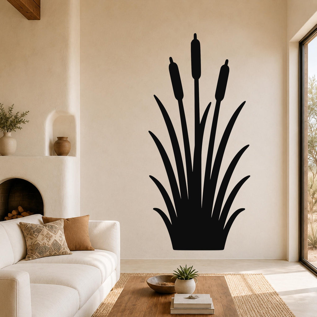 Black metal cattail wall art silhouette with three seed heads, mounted on a living room wall above a white sofa.