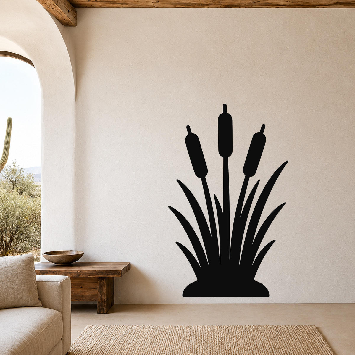 Black metal cattail wall art silhouette with three reeds and leafy base, mounted on a living room wall above a wooden bench.