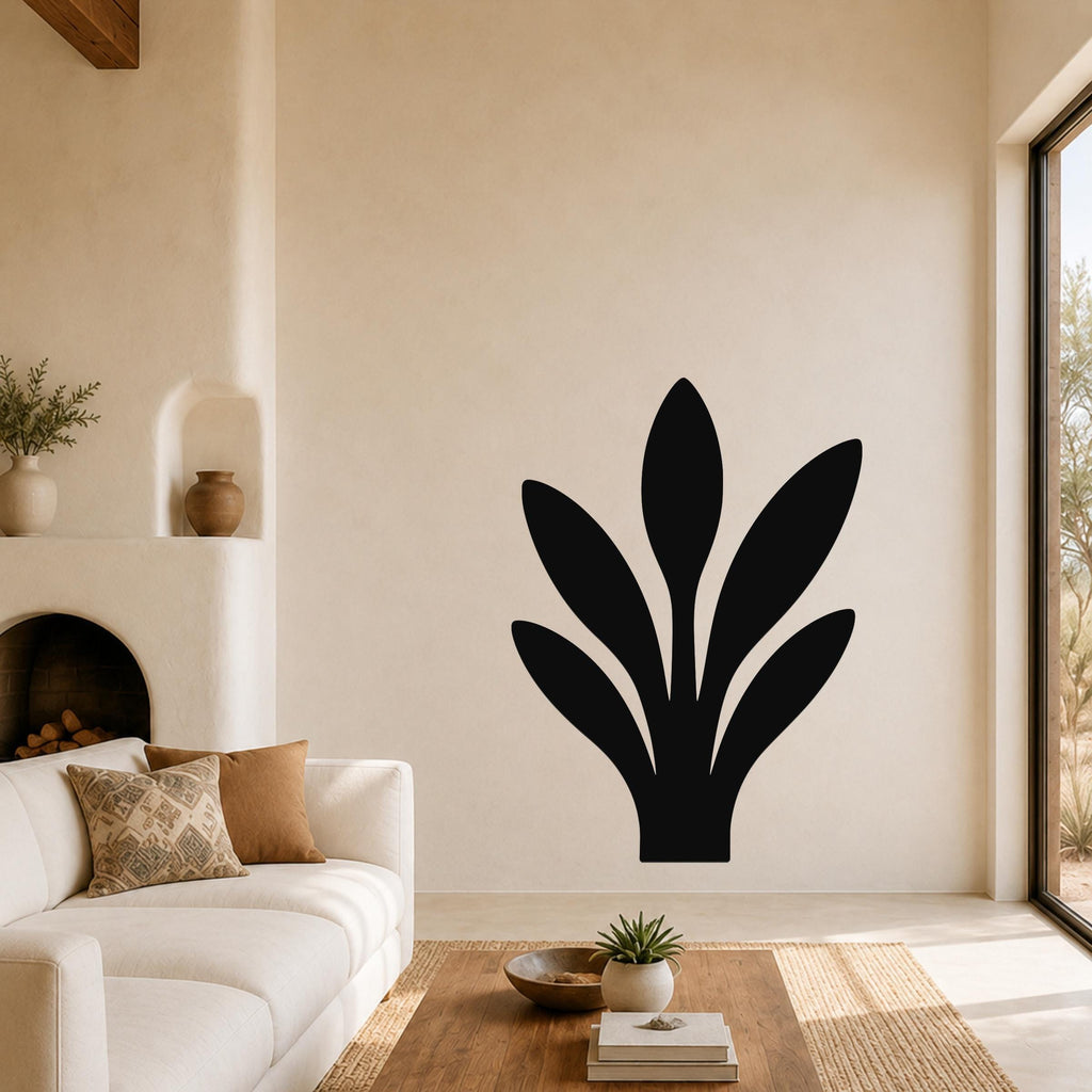 Black metal wall art in a snake plant silhouette, mounted on a living room wall above a sofa.
