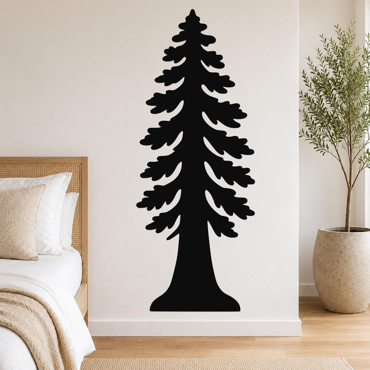 Black metal redwood tree wall art with layered branch cutouts, mounted on a bedroom wall above a bed.