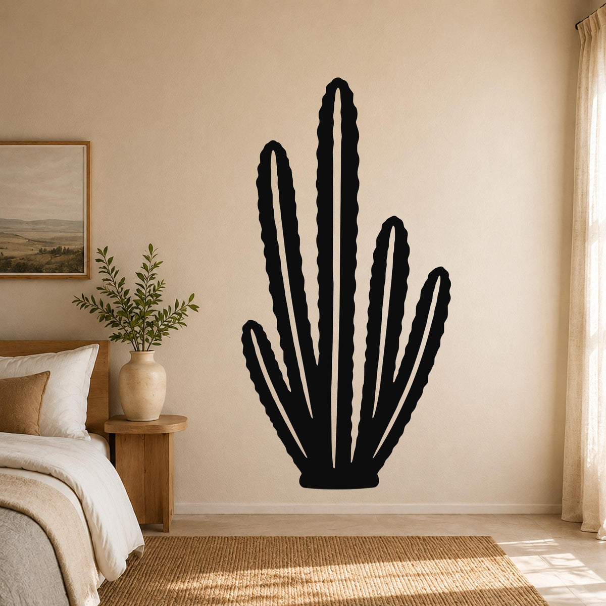 Black metal cactus wall art with multiple vertical arms and internal cutouts, mounted on a beige bedroom wall above a woven rug.