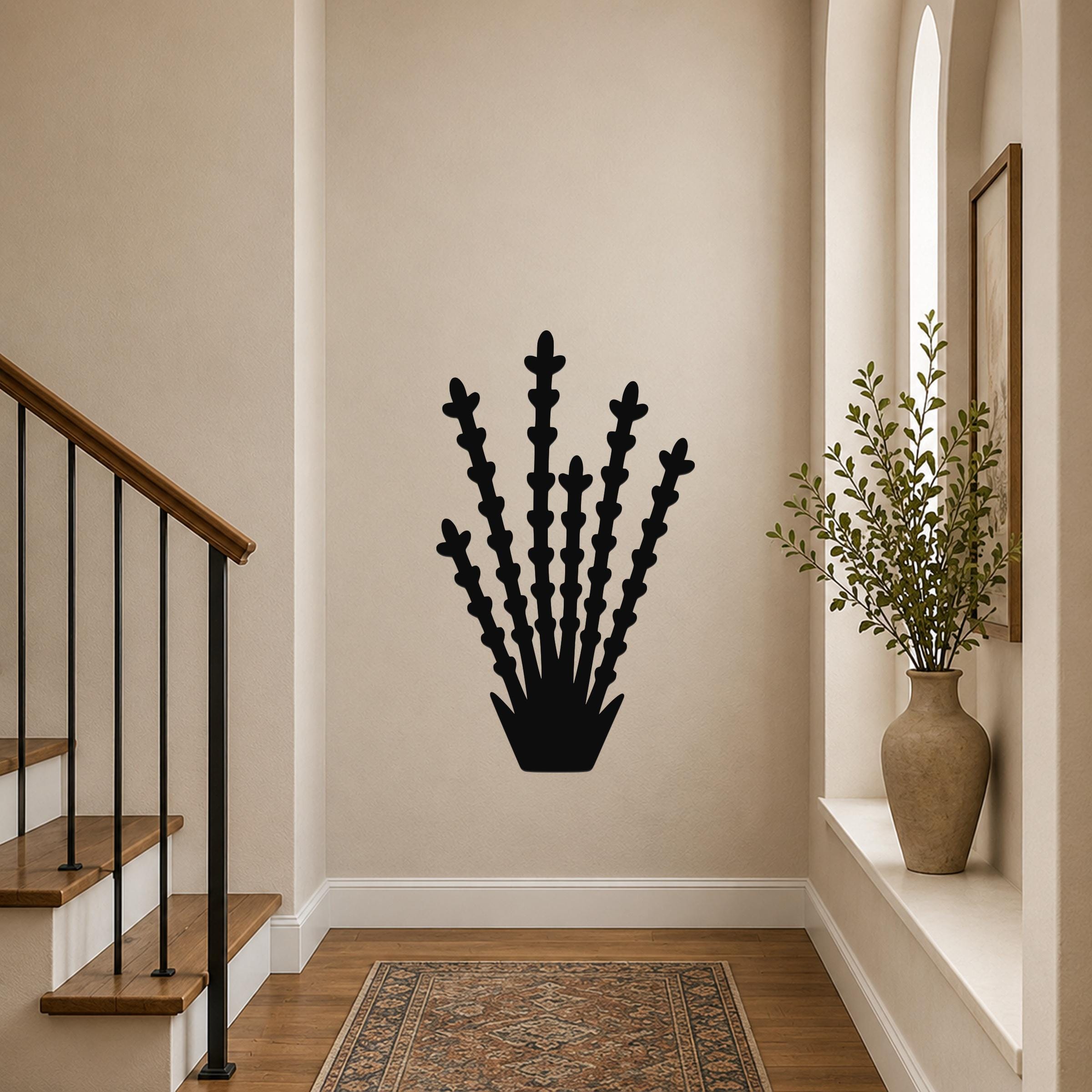 Black metal ocotillo wall art with branching cutouts, mounted on a hallway wall above a patterned rug near a staircase.
