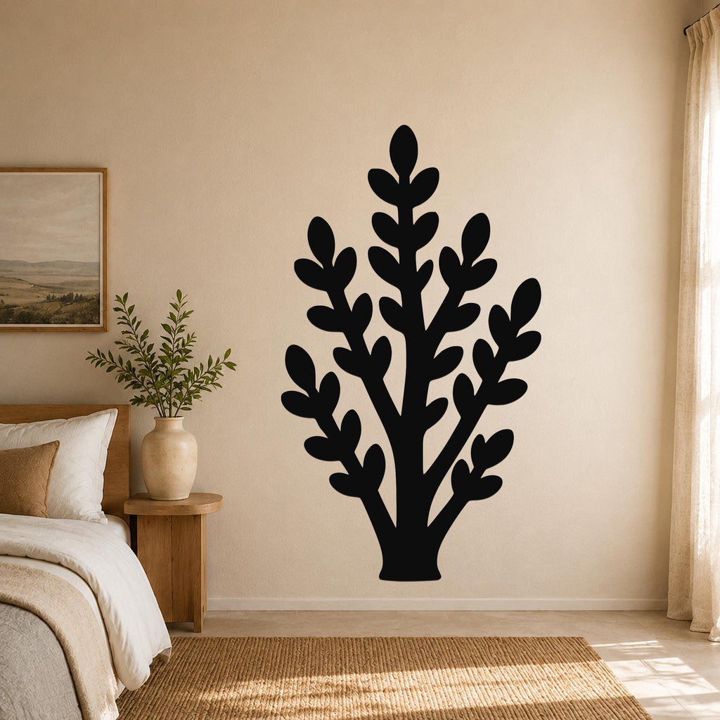 Black metal wall art in a silhouette of a jade plant with layered leaf cutouts, mounted on a beige bedroom wall above a woven rug.