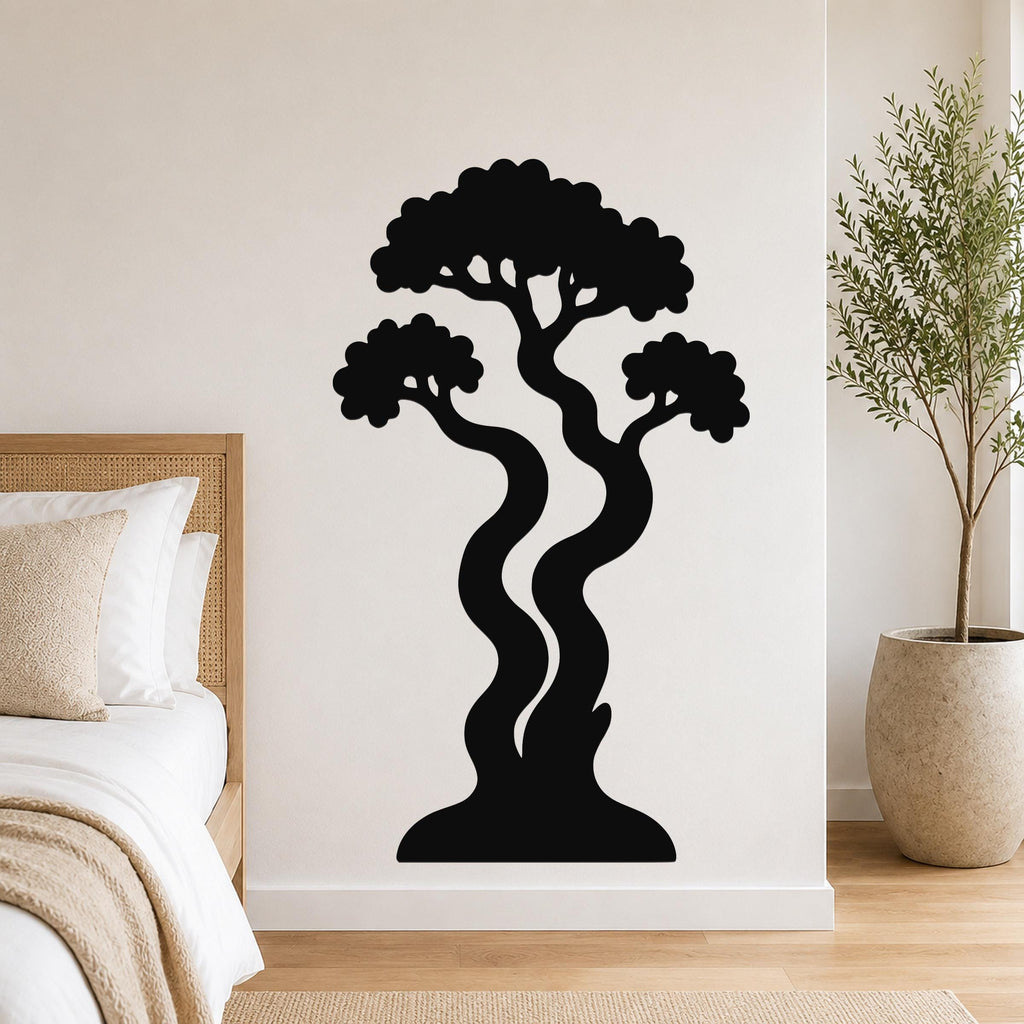 Black metal wall art in a bonsai tree silhouette with wavy trunks and layered canopy, mounted on a bedroom wall above a bed.