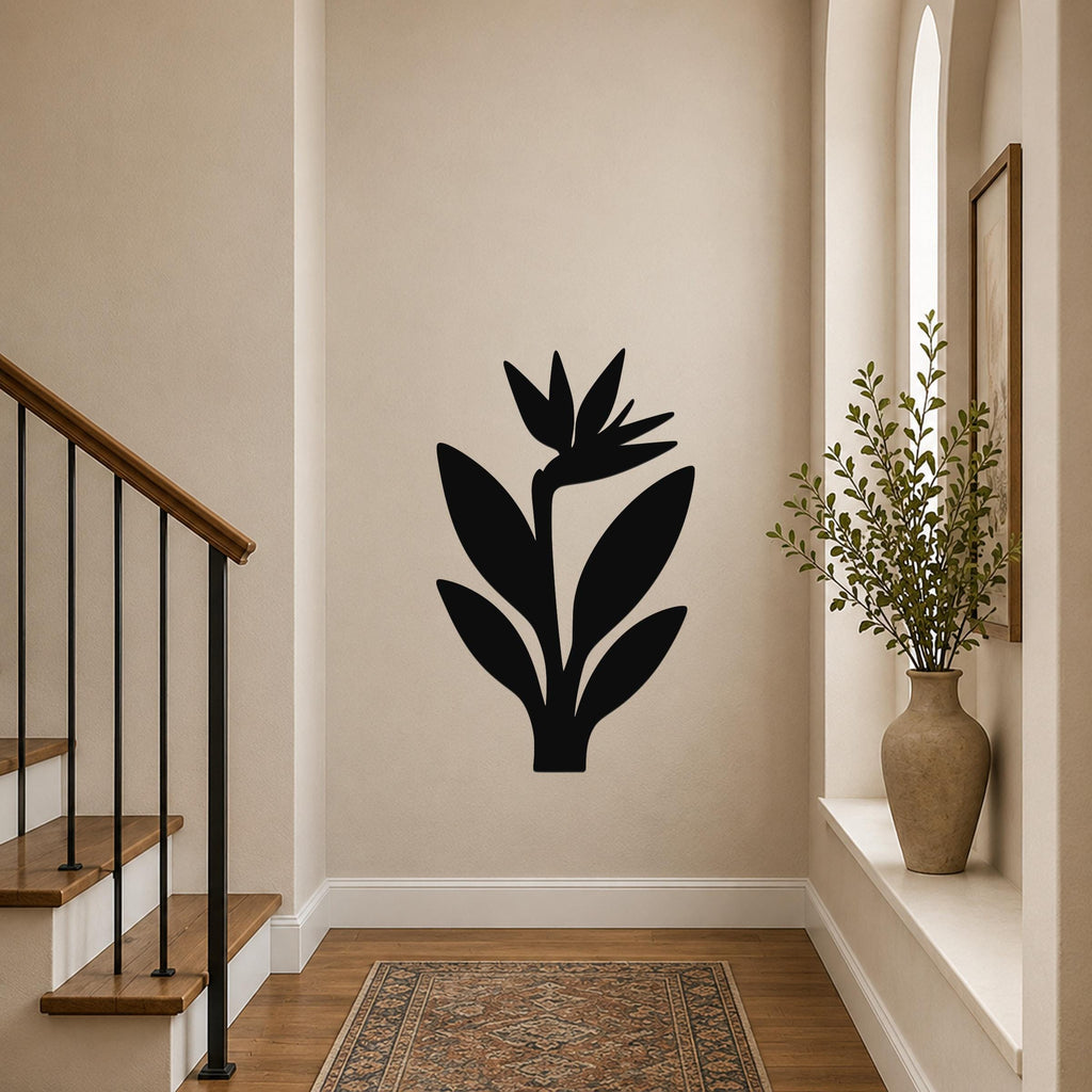 Black metal Bird of Paradise wall art silhouette mounted on a hallway wall above a patterned rug, near a staircase and a vase with greenery.