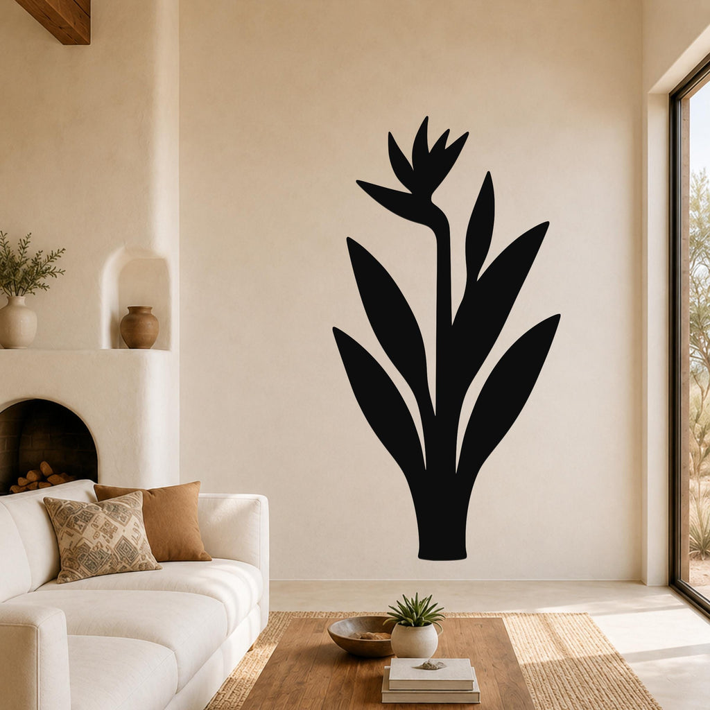 Black metal Bird of Paradise wall art silhouette mounted on a living room wall above a white sofa.