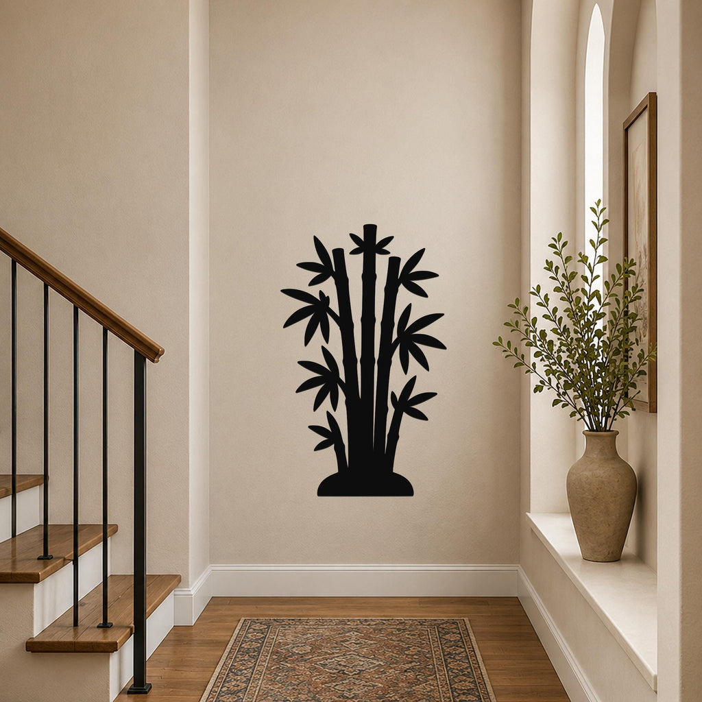 Black metal bamboo wall art silhouette with cutout leaves and stems, mounted on a hallway wall above a patterned rug near a staircase.