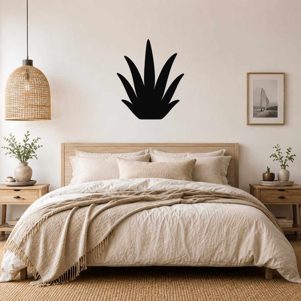 Black metal agave wall art silhouette mounted above a wooden bed in a neutral bedroom.