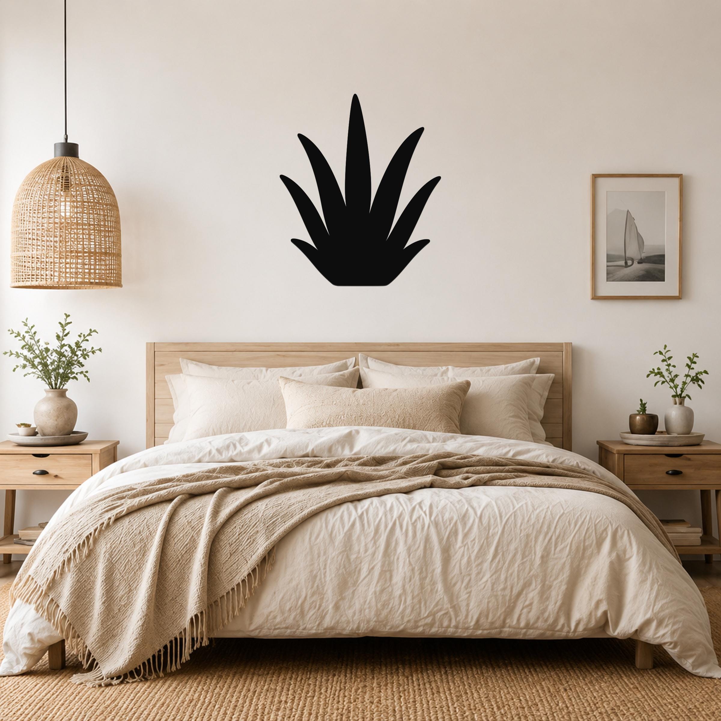 Black metal agave wall art silhouette mounted above a wooden bed in a neutral bedroom.