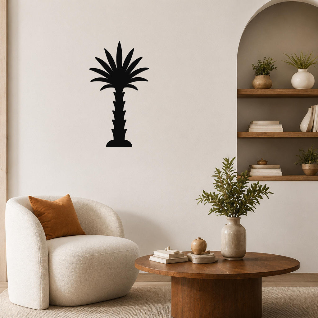 Black metal palm tree wall art silhouette mounted on a living room wall above a round wooden coffee table.