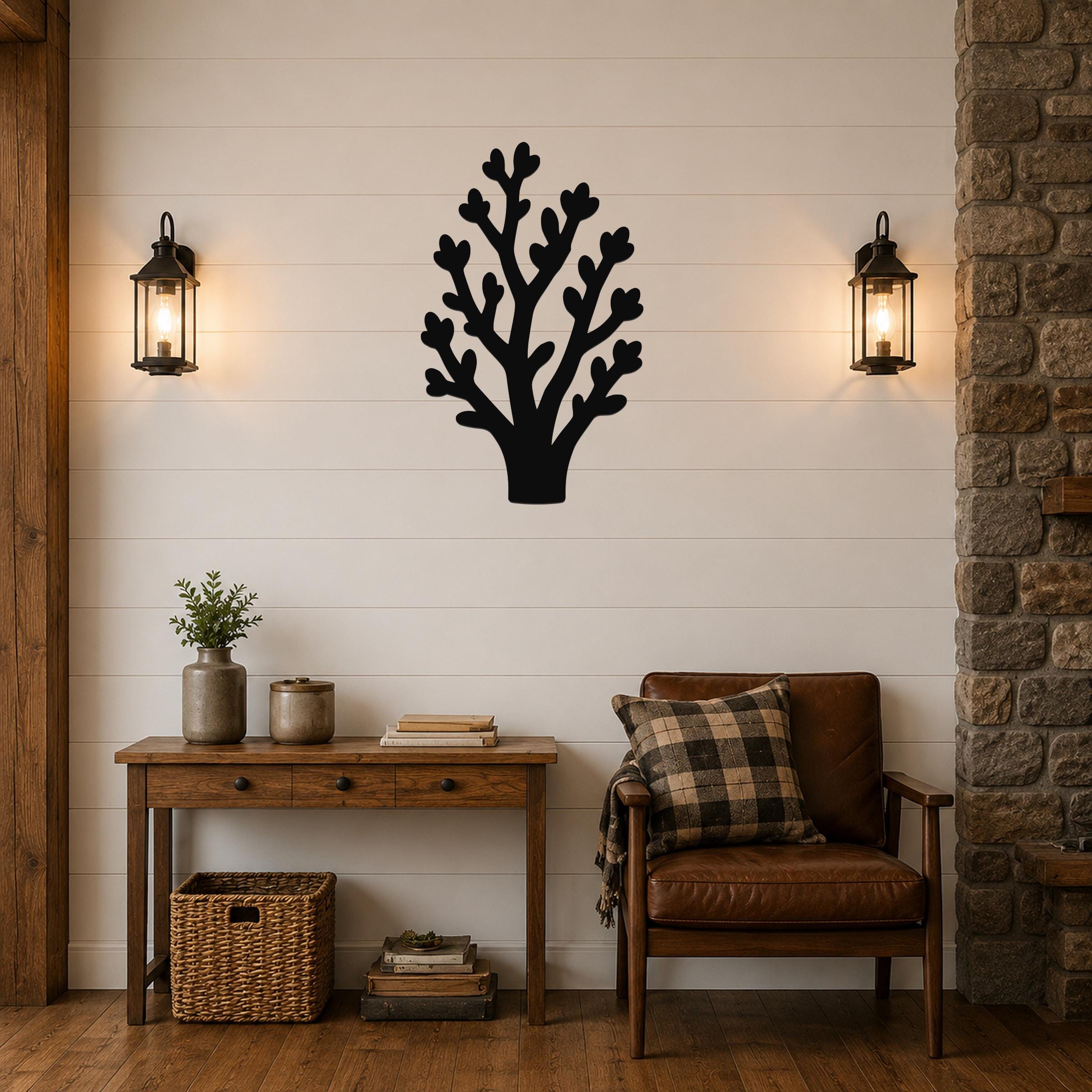 Black metal wall art in a tree silhouette with branching cutouts, mounted on a shiplap wall above a wooden console table in a living room.