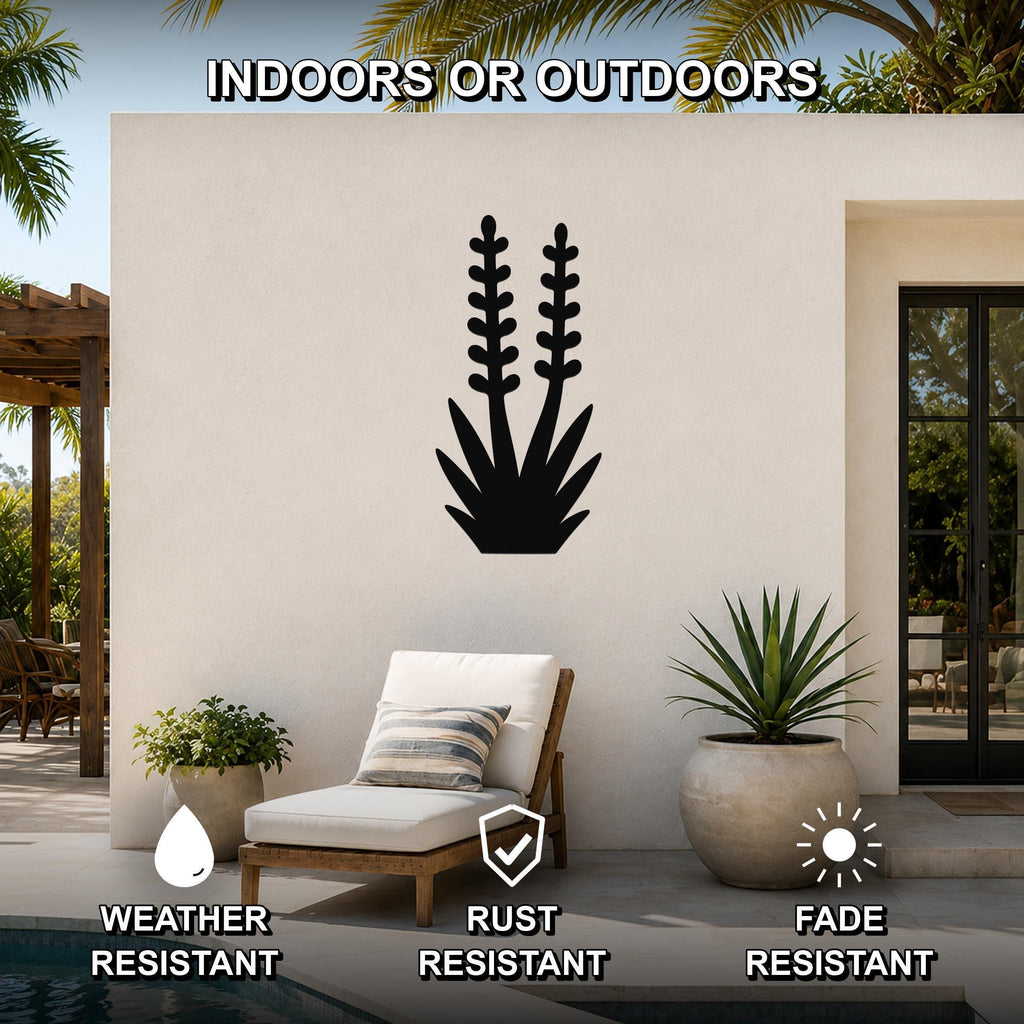 Black metal yucca wall art with leaf and flower cutouts, mounted on an outdoor patio wall above a lounge chair.