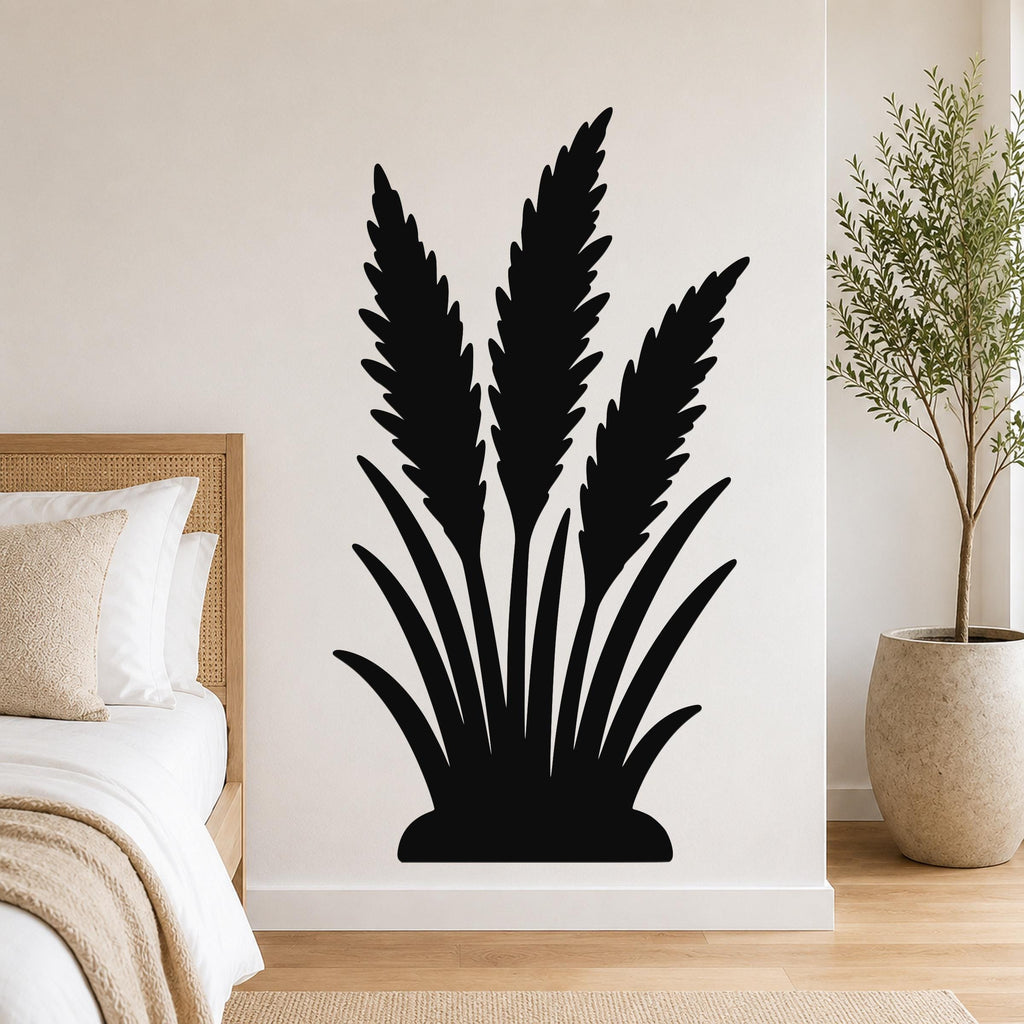 Black metal wall art in a wild grass silhouette design, mounted on a bedroom wall above a bed with a woven headboard.