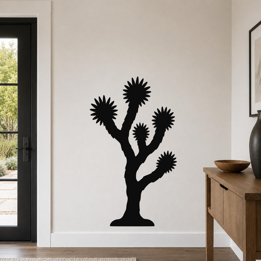 Black metal Joshua tree wall art with starburst-shaped branches, mounted on a white wall in a modern living room.