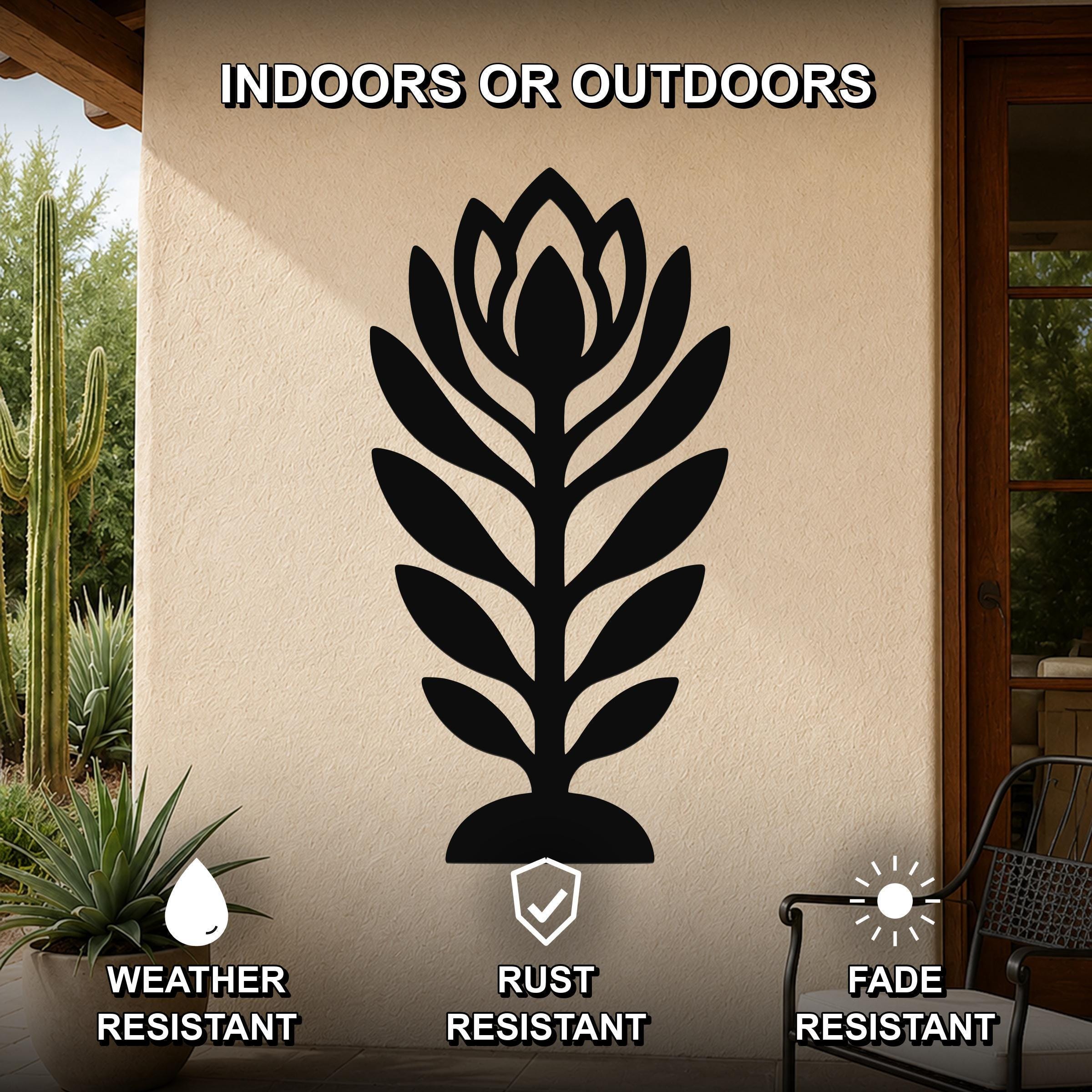 Black metal wildflower wall art with layered leaf and bloom cutouts, mounted on an outdoor patio wall above a potted succulent.