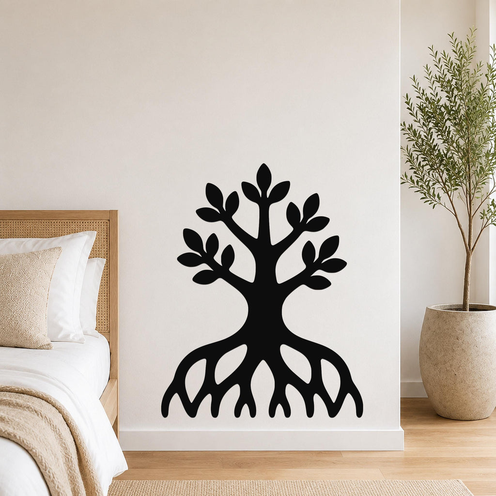 Black metal wall art in a tree silhouette with visible roots and leafy branches, mounted on a bedroom wall above a bed.