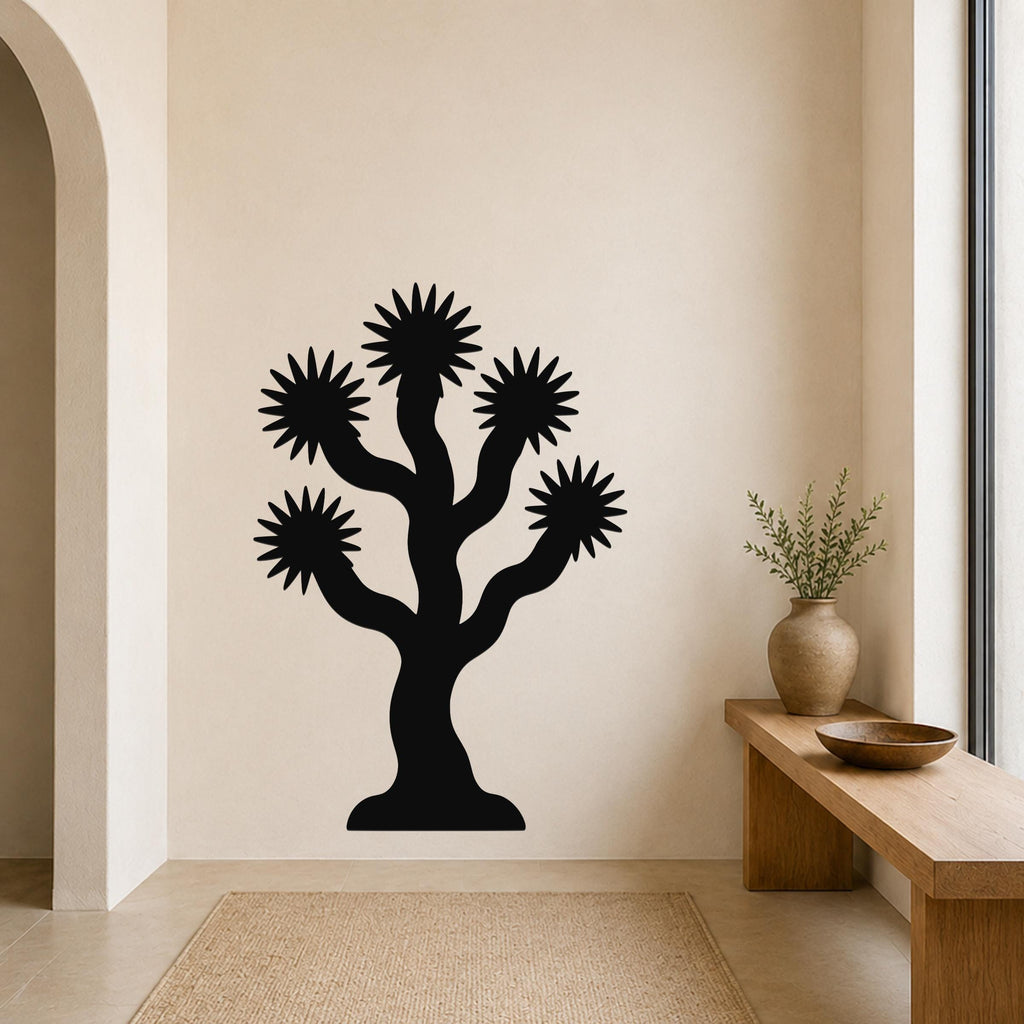 Black metal wall art silhouette of a Joshua tree with starburst-shaped branches, mounted on a beige wall above a wooden bench in a minimalist entryway.